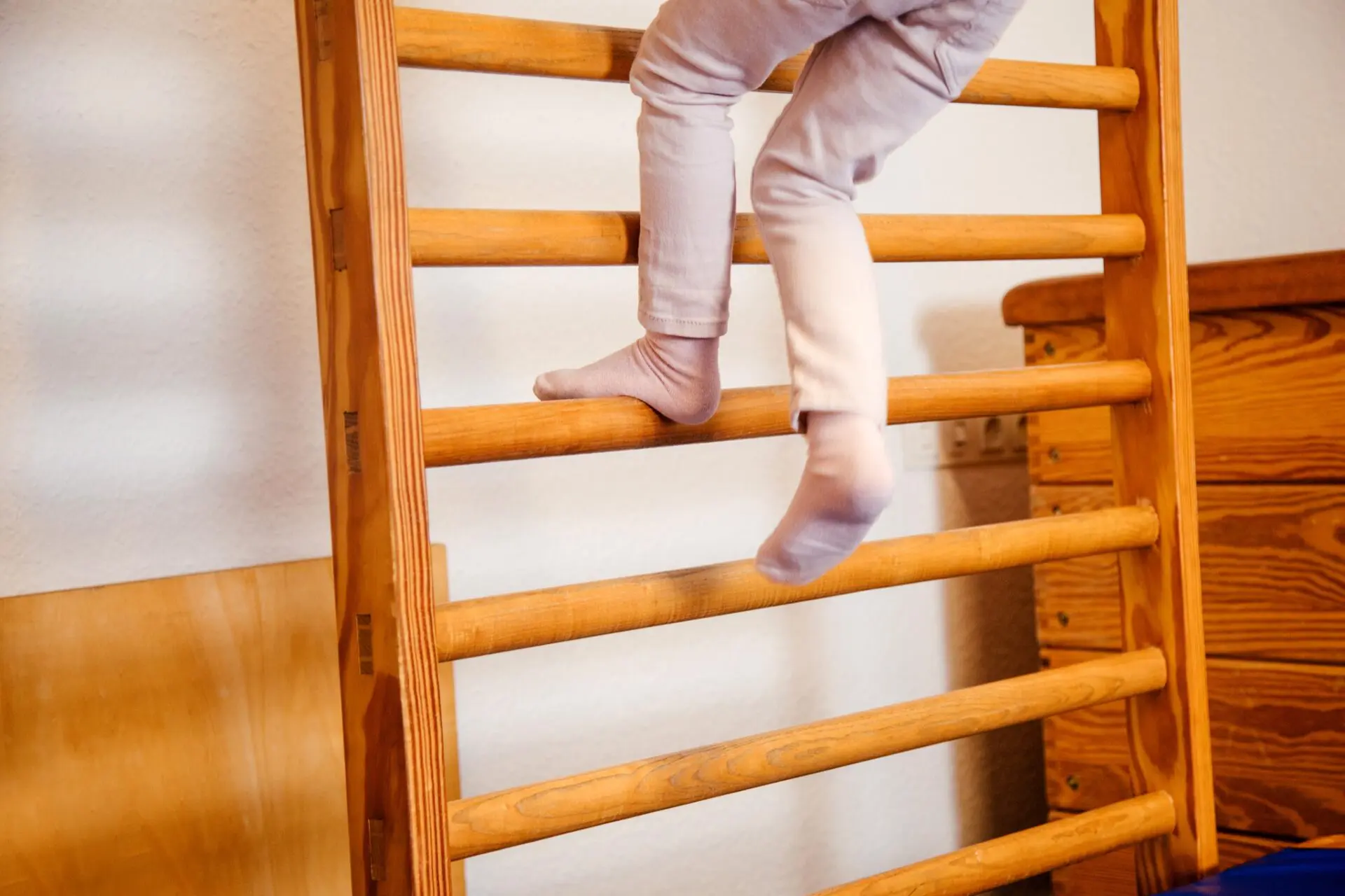 Kind an der Sprossenwand Ergotherapie mit Kindern an Geräten